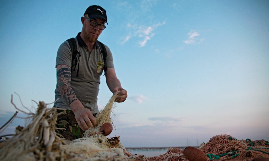 Halászhálókat vizsgál egy önkéntes Sant’Agata di Militellóban. Fotó: Kukka Ranta/The Guardian