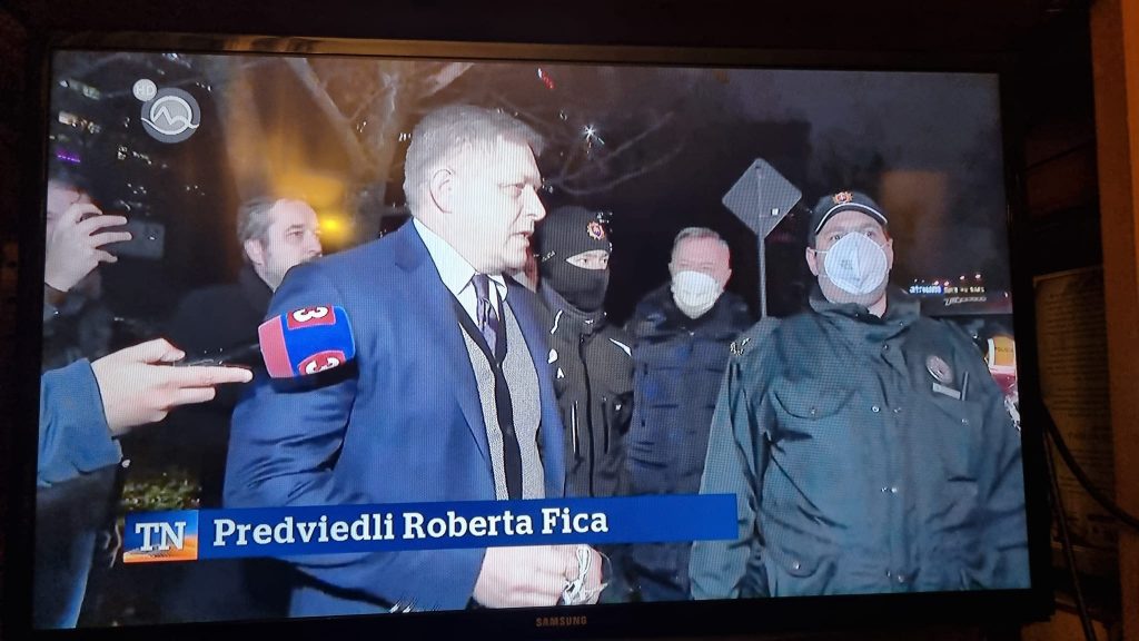 Vezető képünkön azt látják, amikor Robert Fico volt miniszterelnököt rendőrök viszik el kihallgatásra a pozsonyi Tyrs rakpartra szervezett autós demonstráció gyülekezőhelyén 2021 december 16-án csütörtökön az esti órákban. Kép forrása: Bőtös Botond, fotó.