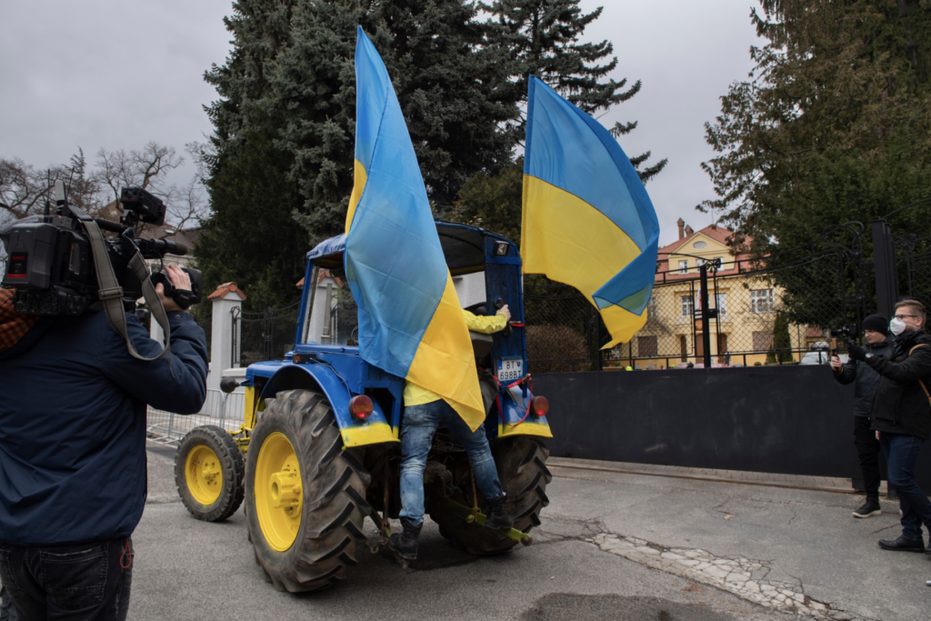 Vezető képünkön egy ukrán nemzeti színekre festett traktoros tüntetést látnak a pozsonyi orosz nagykövetség előtt 2022 március 16-án. Kép forrása: TV Noviny.sk