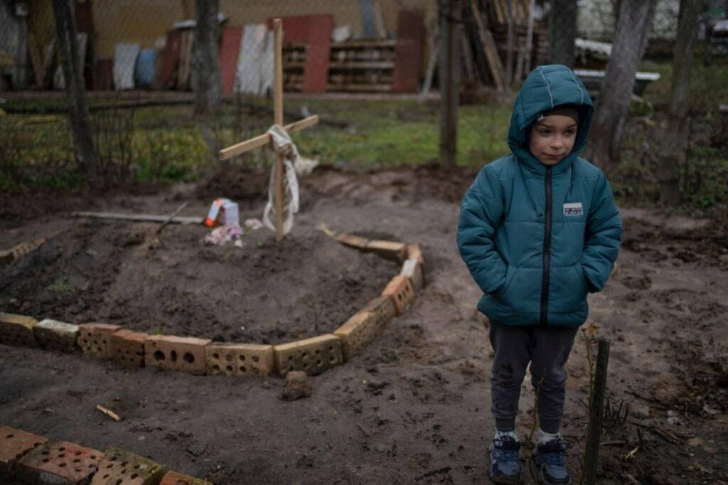 Kezdő képünkön egy 6 éves kisfiú áll édesanyja sírjának közelében, akit orosz katonák gyilkoltak meg, majd az udvarán temettek el Kijevben.